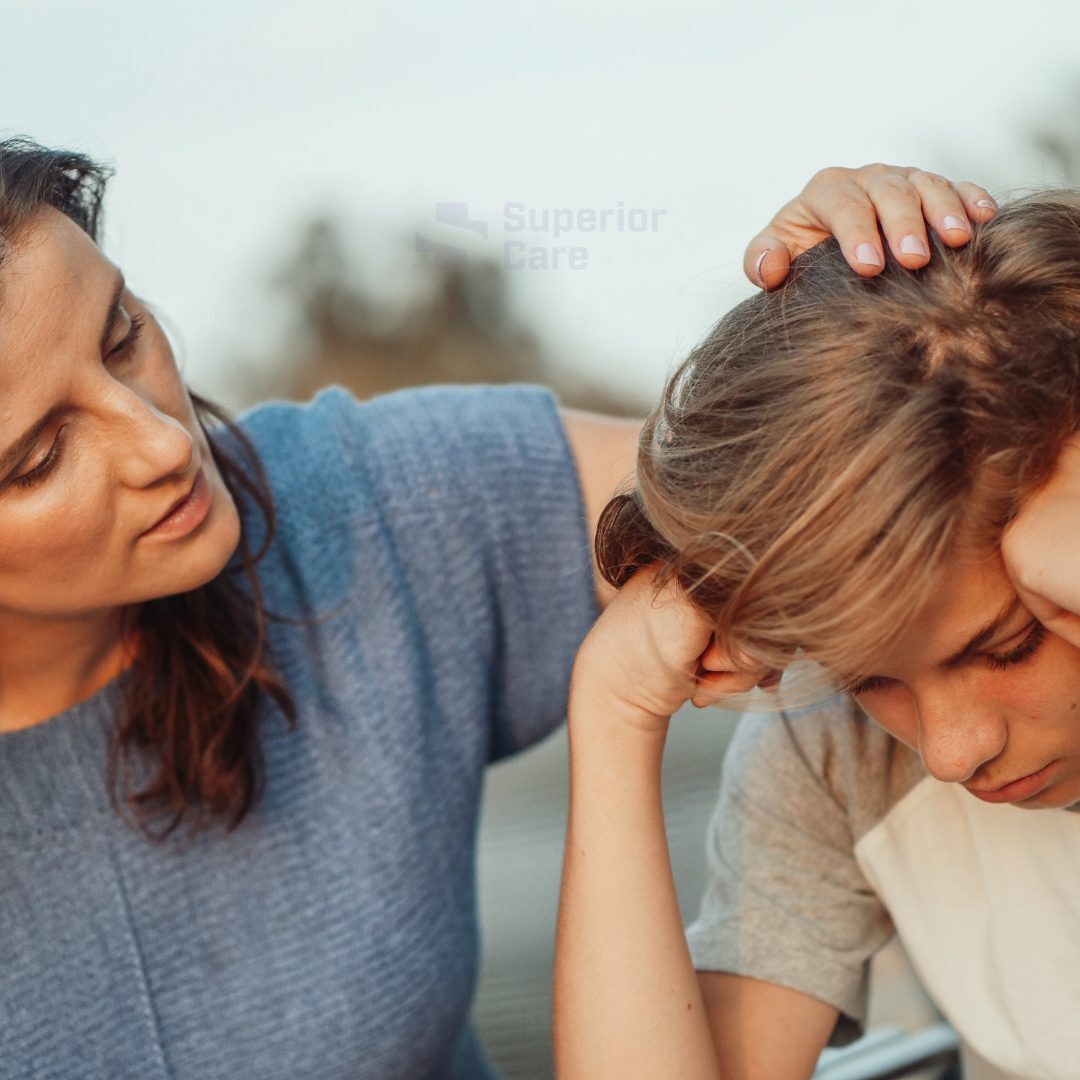 Woman comforting a sad child outdoors.
