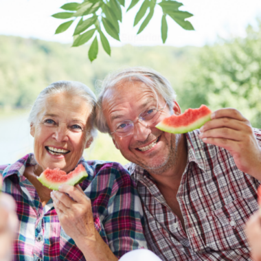 Smiling elderly couple eating watermelon slices
